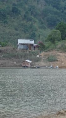 Vietnam 'daki nehir gölünün kıyısındaki küçük bir dağdaki sessiz ahşap ev.