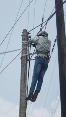 Elektrik kabloları yerleştirmek için Vietnam 'da direkleri kemerle tırmanma yeteneği gerekir.
