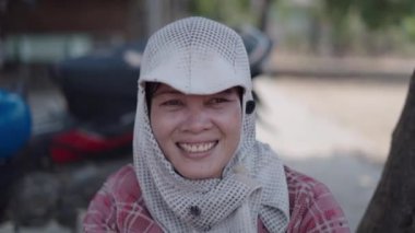 Vietnam 'da şapkalı ve eldivenli genç Asyalı kadın kameraya selam veriyor ve gülümsüyor - 4K Yatay