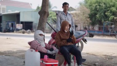 Vietnam 'da yol kenarında sohbet eden ve dinlenen bir grup erkek ve kadın - 4K Yatay