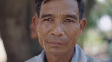 Vietnam 'da gülümsemeden kameraya ciddi ciddi bakan olgun Asyalı bir adamın portresi - 4K Yatay