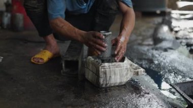 Vietnam 'da benzinle dolu bir konteynırda motor filtresi yıkayan bir tamircinin ağır çekim elleri - 4K Yatay