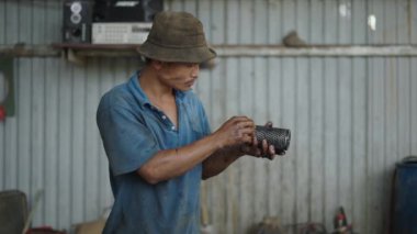 Vietnam 'da küçük bir atölyede yıkadıktan sonra filtreye bakıp kurutan genç Asyalı adam - 4K Yatay