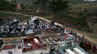 İnsansız hava aracı Vietnam dağlarındaki küçük bir kırsal mezarlığın mezarına çok yakın bir yerde alçaktan uçuyor - 4K Yatay