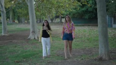 Bir esmer ve bir sarışın, kameraya doğru çıplak ayakla yürüyorlar. Onlara yaklaşmalarını işaret ediyorlar. 4K Yatay.