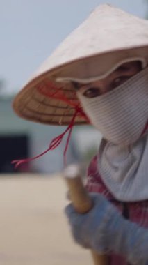 Vietnam 'da kurutmak için pirinç tırmıklayan genç Vietnamlı adam.