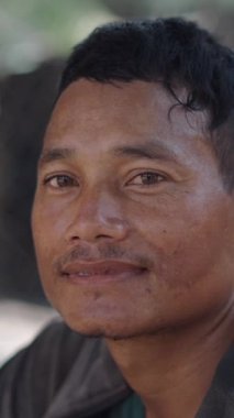 Vietnam 'da kameraya el sallayan ve gülümseyen Asyalı genç bir adamın portresi.