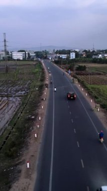 İnsansız hava aracı, Vietnam 'da şehre doğru giden birçok motosikletle meşgul. FullHD Dikey