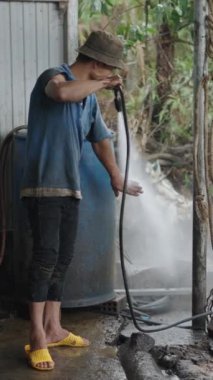 Vietnam 'da küçük bir atölyede çalıştıktan sonra ellerini ve kollarını yıkayan genç bir tamirci