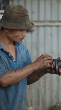 Vietnam 'da küçük bir atölyede yıkadıktan sonra filtreye bakıp kurutan genç Asyalı adam