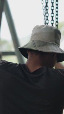 Vietnam 'da bir motoru kaldırmak için zincir çeken tamirci olarak çalışan Asyalı genç adam FullHD Dikey