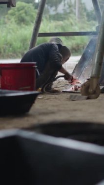 Vietnam 'da küçük bir yol kenarı atölyesinde birkaç güvenlik önlemi almış genç Asyalı tamirci.