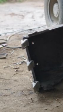 Bir kazıcının ağır küreğini devirmeye çalışan genç bir tamirci metal bir çubuk olan FullHD dikey