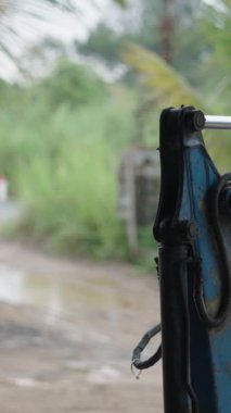 Yağmurlu bir günde Vietnam 'daki küçük aile atölyesinin girişinde su birikintileri ve çamur.