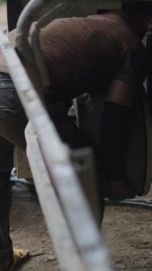 Aile atölyesinde çalışan ve büyük bir kamyonun fren davulunu söken genç kardeşler.