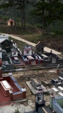 İnsansız hava aracı Vietnam dağlarındaki küçük bir kırsal mezarlığın mezarına çok yakın bir yerde alçaktan uçuyor.