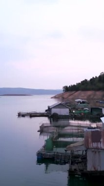 İnsansız hava aracı, Vietnam 'daki göl kenarındaki balıkçı kulübelerinin üzerinden uçuyor.