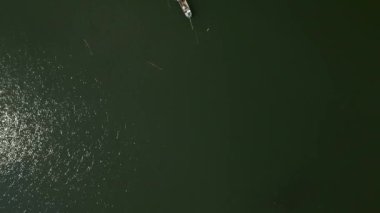 Vietnam 'daki büyük nehrin ortasındaki küçük balıkçı teknesinin yüksek irtifa görüntüsü - 4K Yatay