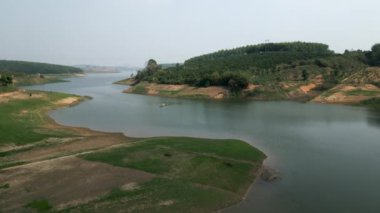 Bir balıkçı ve teknesi, Vietnam 'ın göbeğindeki büyük bir nehrin ortasında yapayalnız.