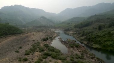 Vietnam 'ın dağları ve vadileri arasında dar ve alçak akan bir nehirde durgun su - 4K Yatay