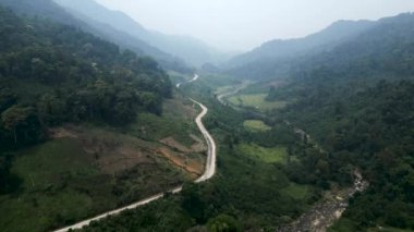 Vietnam 'ın dağları ve ormanları arasında trafiğin olmadığı dar ve ıssız bir yol var - 4K Yatay