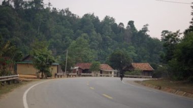 Vietnam 'da küçük bir köyde büyük bisikletli çocuklar tehlikeli bir şekilde karşıdan karşıya geçiyorlar - 4K Yatay