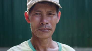 Asyalı Vietnamlı adam kameraya kötü dişli hareketsiz bakıyor - 4K Yatay