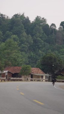 Vietnam 'daki küçük bir köyde büyük bisikletli çocuklar tehlikeli bir şekilde karşıdan karşıya geçiyorlar.