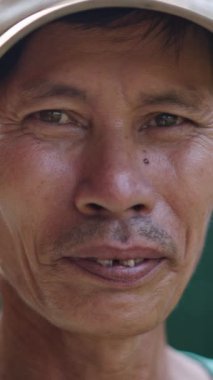 Olgun Asyalı Vietnamlı bir adamın portresi şapkalı ve kötü dişli FullHD dikey.