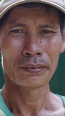 Asyalı Vietnamlı bir portre kameraya kötü dişli hareketsiz bakıyor.