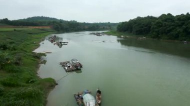 İnsansız hava aracı Vietnam 'daki büyük nehirde, dağlar ve bitki örtüsü arasında uçuyor. 4K Yatay