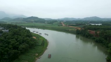 Vietnam 'daki büyük nehir yeşil vadiyi çevreleyen büyük dağların arasında - 4K Yatay