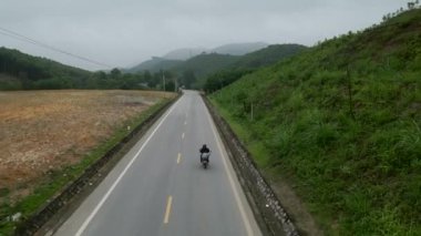 Vietnam 'da üzerinde eski bir motosiklet bulunan bir yolun kuş bakışı görüntüsü - 4K Yatay