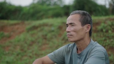 Ormanda oturan küçük bıyıklı, beyaz saçlı, olgun Asyalı bir adamın portresi - 4K Yatay