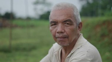 Kameraya bakan kısa beyaz saçlı olgun Asyalı adam portresi - 4K Yatay