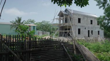 Şehirden ve Vietnam 'daki yeşilliğin yakınındaki kırsal alanda yapım aşamasındaki lüks bir ev - 4K Yatay