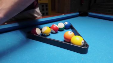 Yetişkin erkeklerin elleri maçtan önce bilardo toplarını üçgen raflara yerleştirirken - 4K Yatay