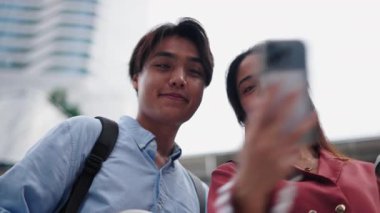 Selfie çeken ve gökdelenlere hayran olan genç turistler - 4K Yatay