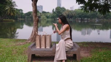 Alışveriş sonrası yeni kıyafetleri kontrol eden tüketici - 4K Yatay