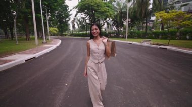 Sokakta elinde poşetlerle dolaşan genç bir kadın - 4K Yatay