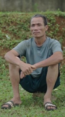 Vietnam 'da hareket etmeden şapkasının yanında oturan Asyalı çobanlar FullHD Dikey