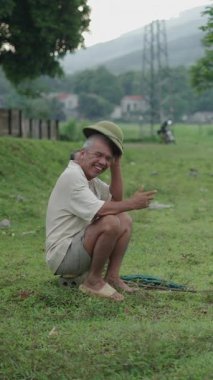 Hayvanlar Vietnam 'ın çayırlarında çim yerken çobanlar dinleniyor ve gülümsüyor.