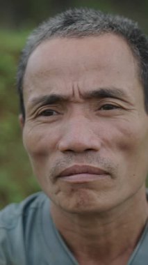 Vietnam 'da kameraya bakan ciddi hareketsiz Asyalı çobanın portresi FullHD Dikey