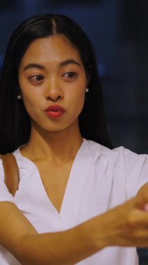 Sıska, genç Asyalı kız akıllı telefonunun önünde Tayland 'da gece vakti büyük şehirde fotoğraf çekmek için el kol hareketi yapıyor.