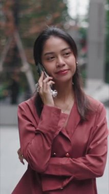 İş kadını şehirde yürürken telefonla konuşuyor - FullHD Dikey