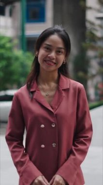 Genç Asyalı iş kadını şehir ortamında gülümsüyor - FullHD Dikey