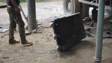 Bir kazıcının ağır küreğini devirmeye çalışan genç bir tamirci, metal bir çubuğa yardım etti - 4K Yatay