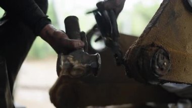 Bir teknisyenin eli çekiç ve penseyle pimi dingilden çıkartırken görülüyor. 4K Yatay