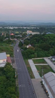 Tayland ovasından kuş bakışı yol üstündeki ormanın yakınındaki FullHD dikey bir kırsal alanda.