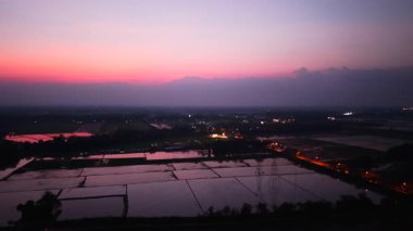 Güneş ışığı Nakhon Sawan Ovası 'nın sularından yansıyor alacakaranlıkta yol kenarında - 4K Yatay